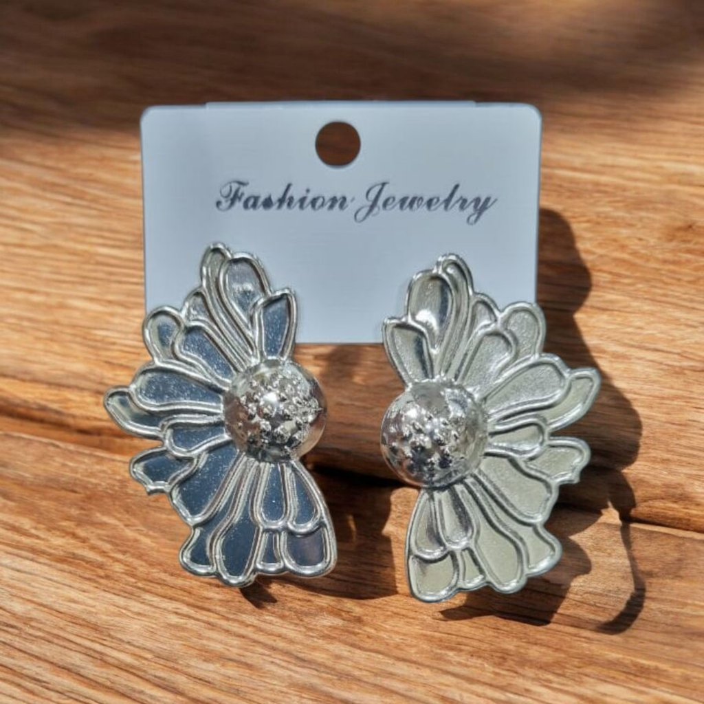 Silver floral earrings on a 'Fashion Jewelry' card against a wooden background